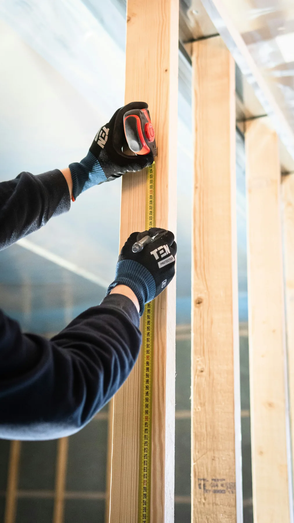 Ironclad crew member measuring wall framing during a Reno home renovation